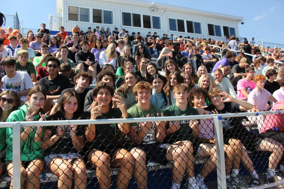 High school students excitedly watch the game from the home bleachers.