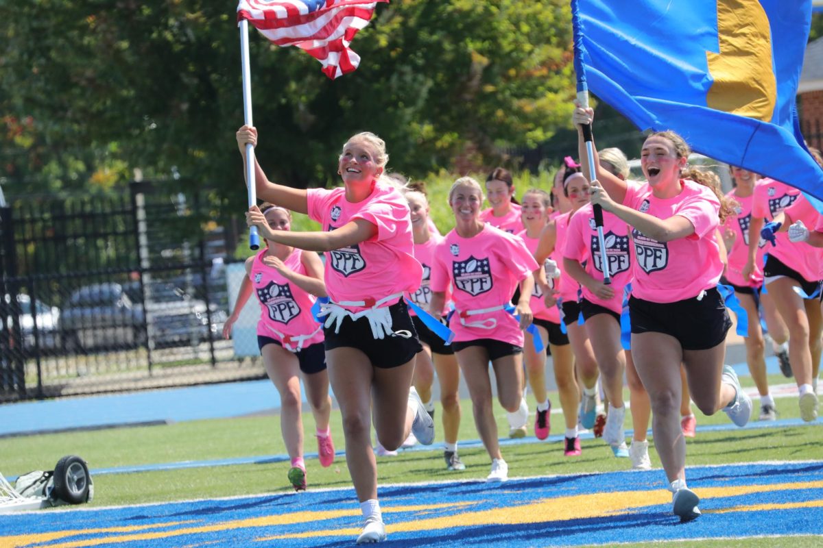 Seniors Haley Wilson (left) and Anna Jirmasek (right) lead the senior girls onto the field.