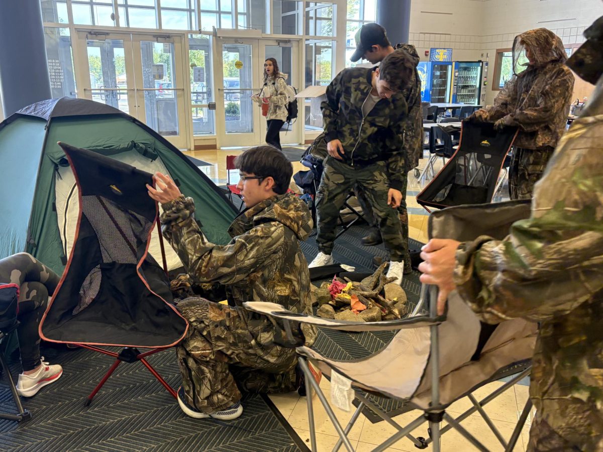 Hustle and bustle to set up a special Camo Day makeshift campfire. Featuring (left to right): Nathan Lu, Lauren Olexa , Matthew Shamblen, Tate McGovern, Grady Wachs.