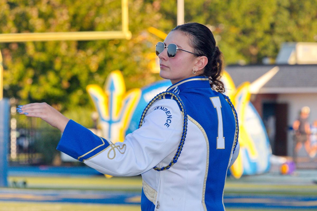 Nora Olexa collaborates with fellow commanders (not shown) Will Stray and Tillie Averre to lead the marching band.