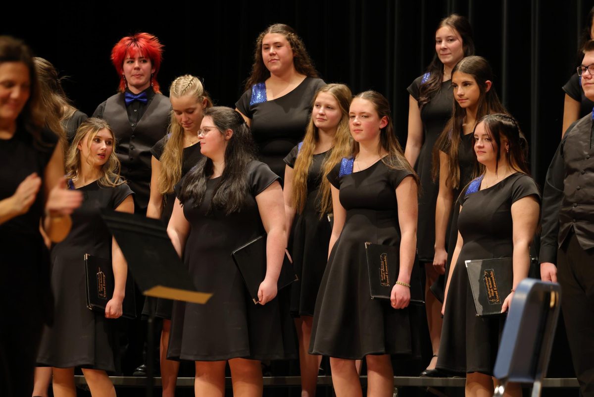 A group of students waiting for the next song to sing during the winter concert.
