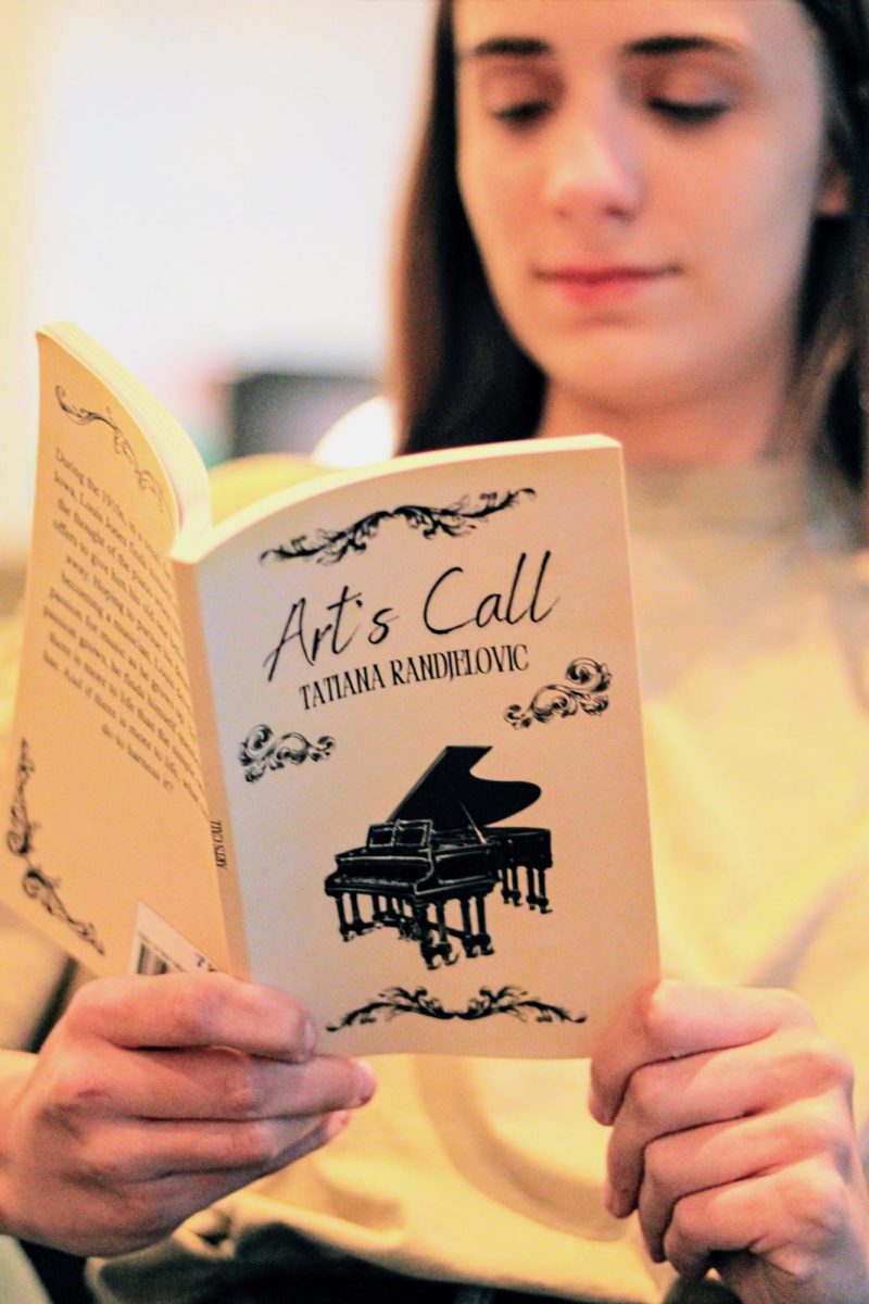 Senior Tatiana Randjelovic posing with her newly published book "Art's Call."
