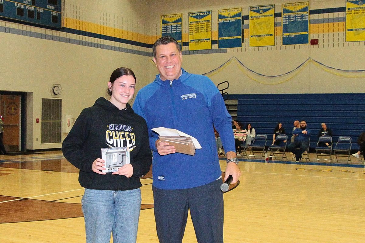 Senior Brooke Vollman and Mr. Janatovich posing with Vollman's award for best "Foody Finds" photo in The Spectator's NYC photo contest.