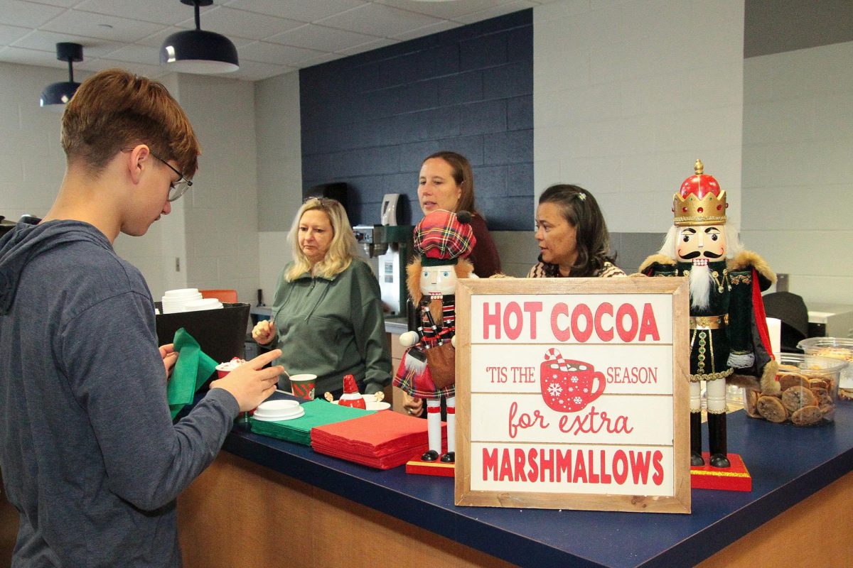 PTO volunteers Nadine Londrico, Jodi Shepard, and Chanice Newcomer serving cocoa at IHS. Freshman Alex Jaworski on left.