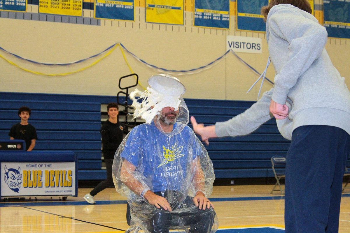 Mr. Mark Corpuz is splattered with whipped cream and water by Junior Kaden Schuette.