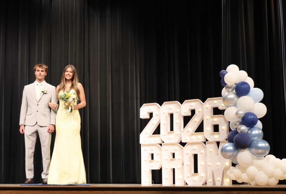Elyse Grill '26 escorted by Jakob Jurkiewicz '26 down the Blue Carpet 