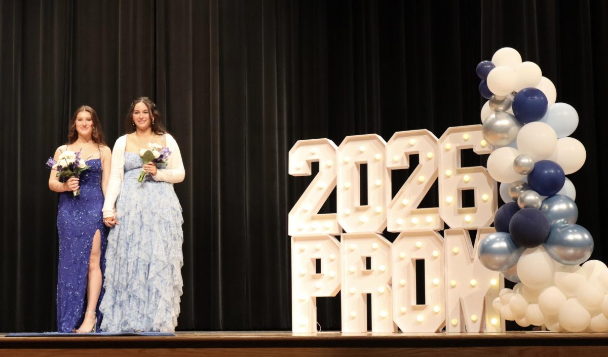 Rabecca Gibson '26 and date walking down the Blue Carpet 