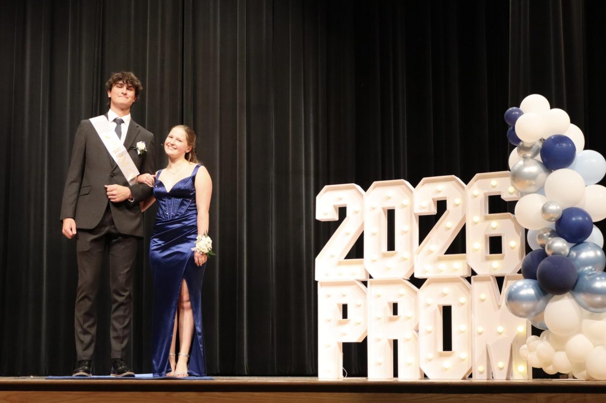 Brooke Coldsnow '26 escorted by Anthony Sobonya '26 down the Blue Carpet 